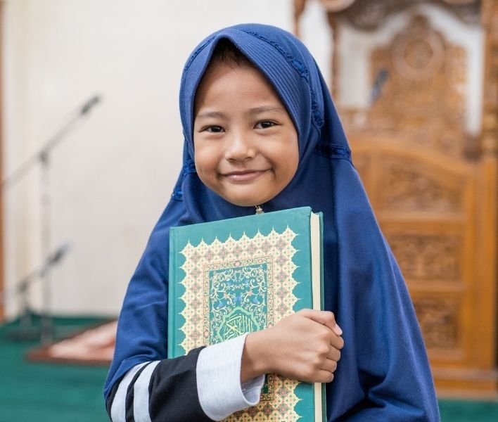 Happy student holding the Quran